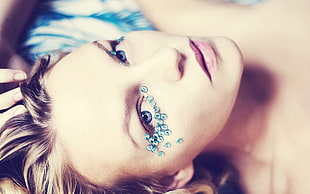 shallow focus photography of blonde haired woman with beads on eye